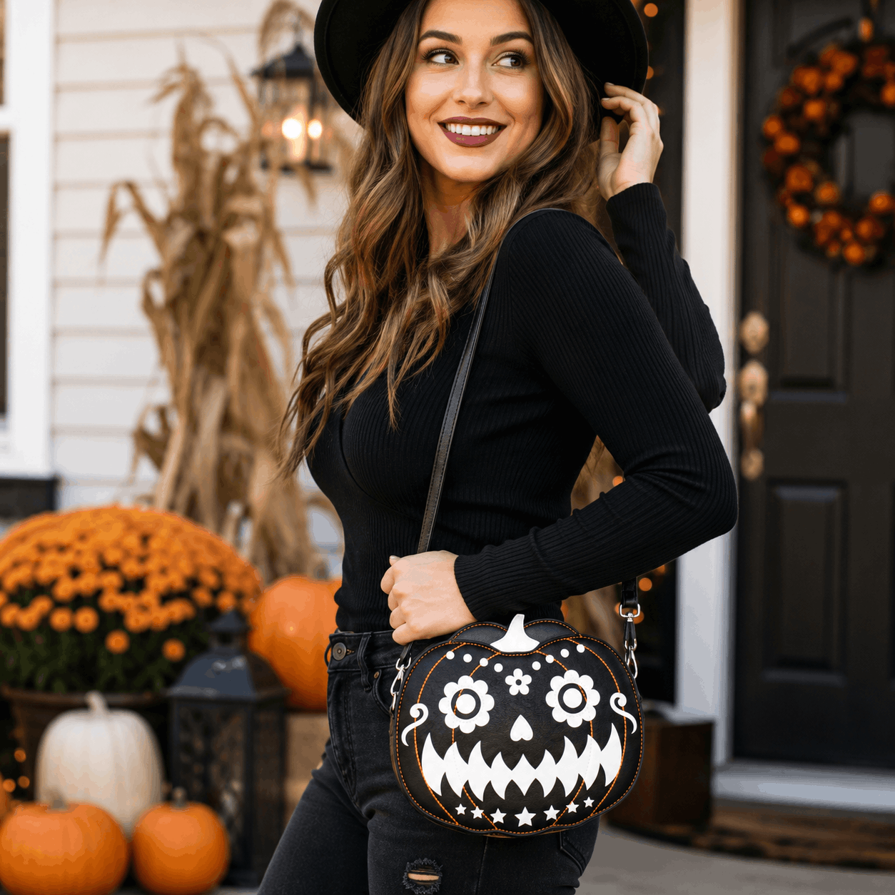 Woman carrying a glow-in-the-dark pumpkin crossbody bag in a festive Halloween setting