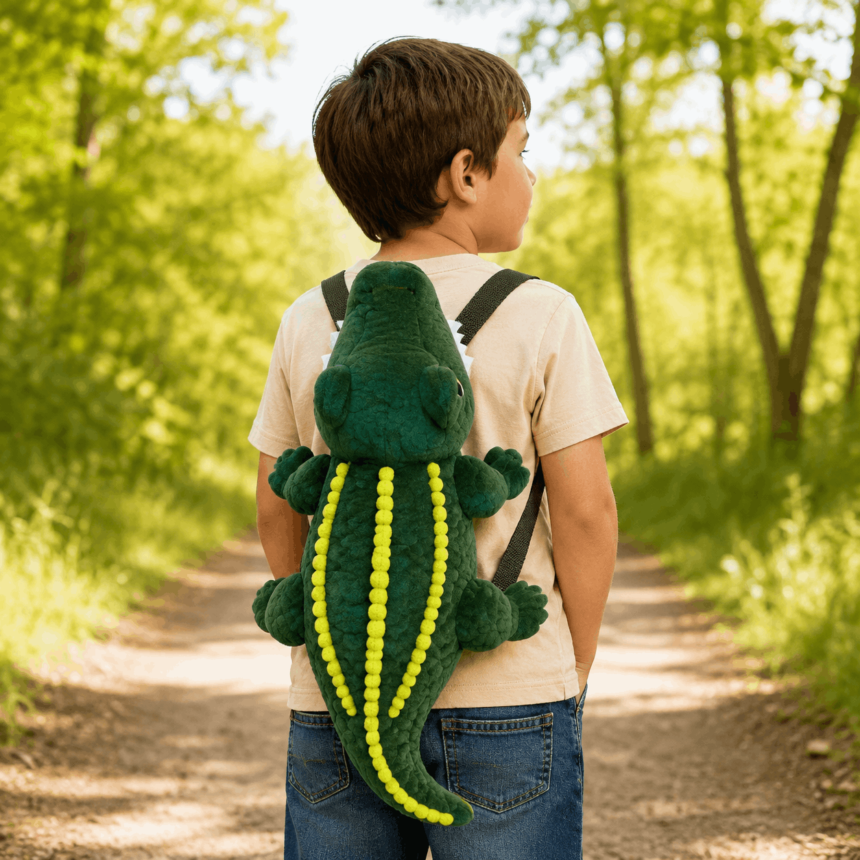 Child wearing the Plush Alligator Backpack outdoors, showing how the novelty backpack looks when worn from the back.