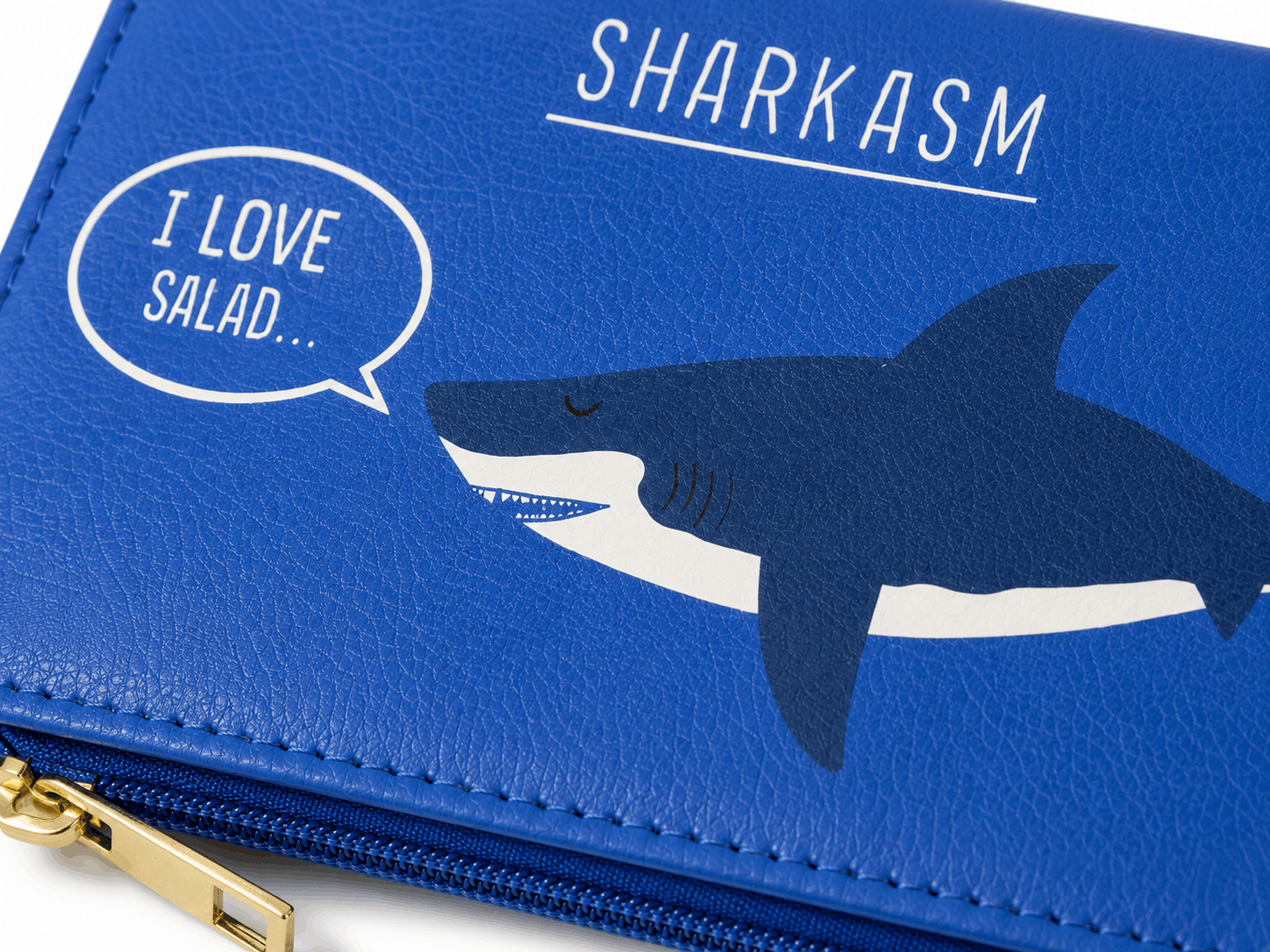 Close-up of the Sharkasm bifold wallet highlighting the shark artwork, textured vinyl material, and stitching