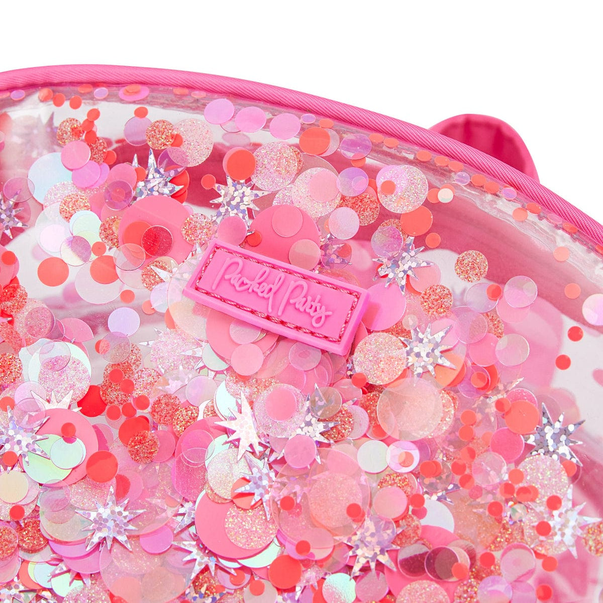 Close-up of Sweet Tart pink confetti and the Packed Party logo on the clear backpack.