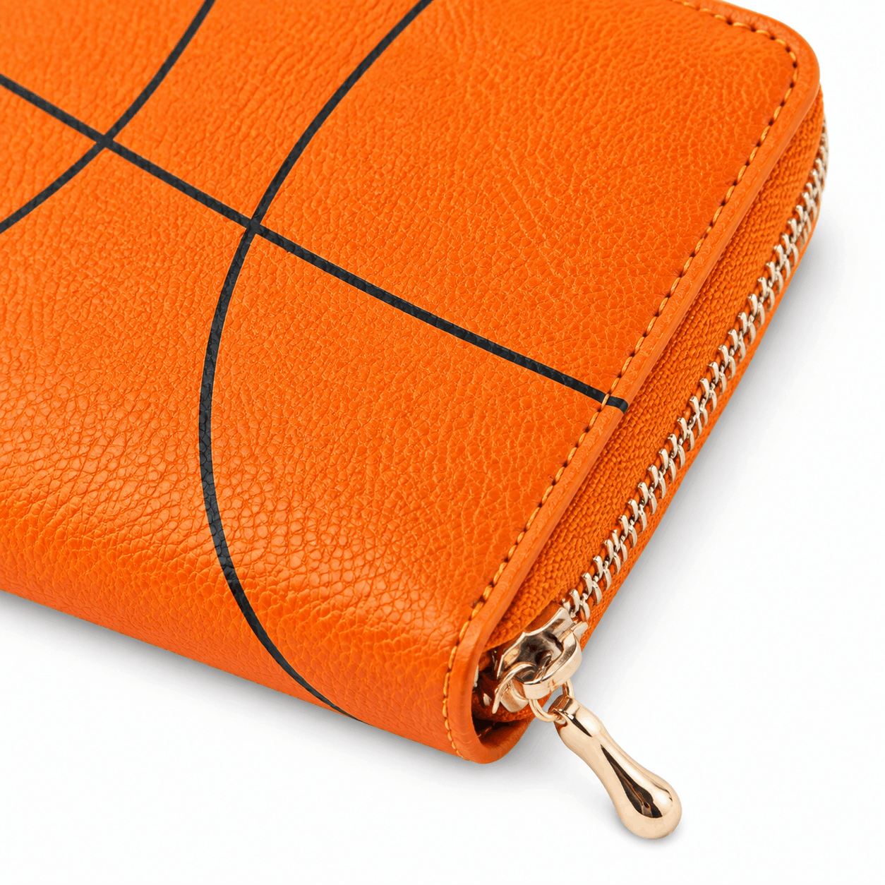 Close-up of orange pebbled texture, stitching, and gold-tone zipper