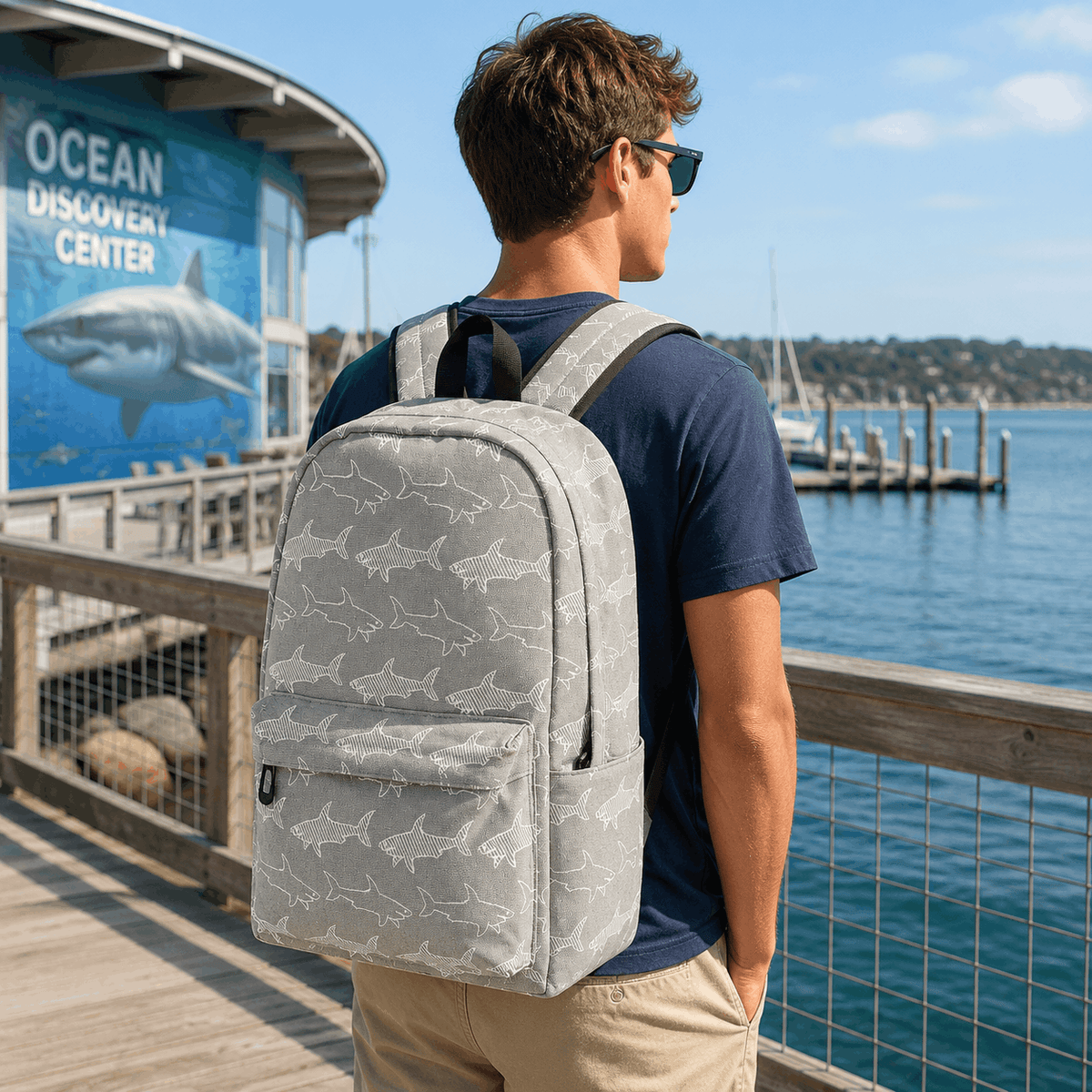 Person wearing a Great White Shark backpack outdoors near the coast