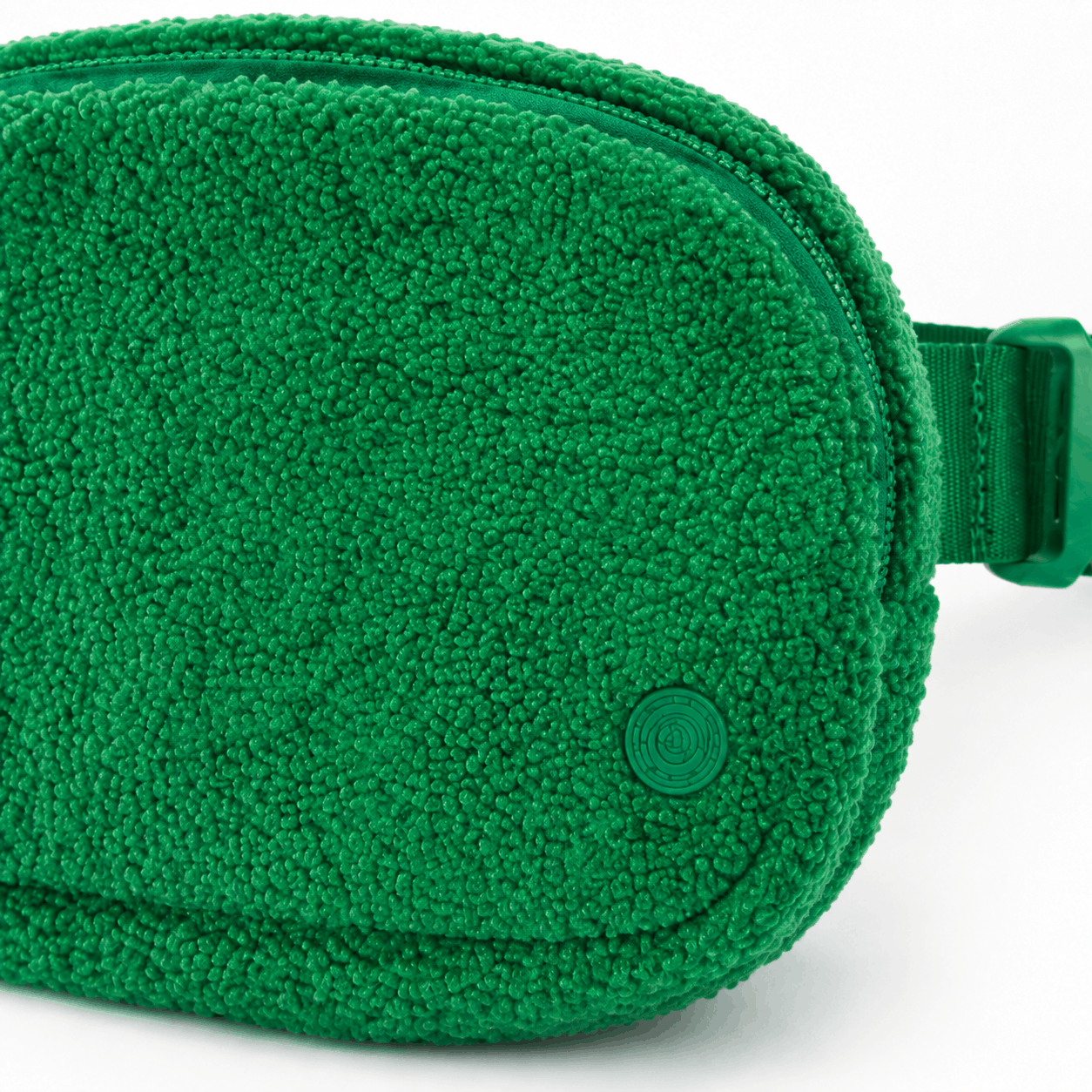 Close-up of the green fleece texture, zipper, stitching, and tonal emblem