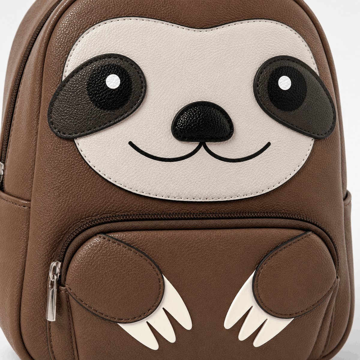 Close-up of the mini sloth backpack showing the sloth face, textured vinyl, and front pocket details