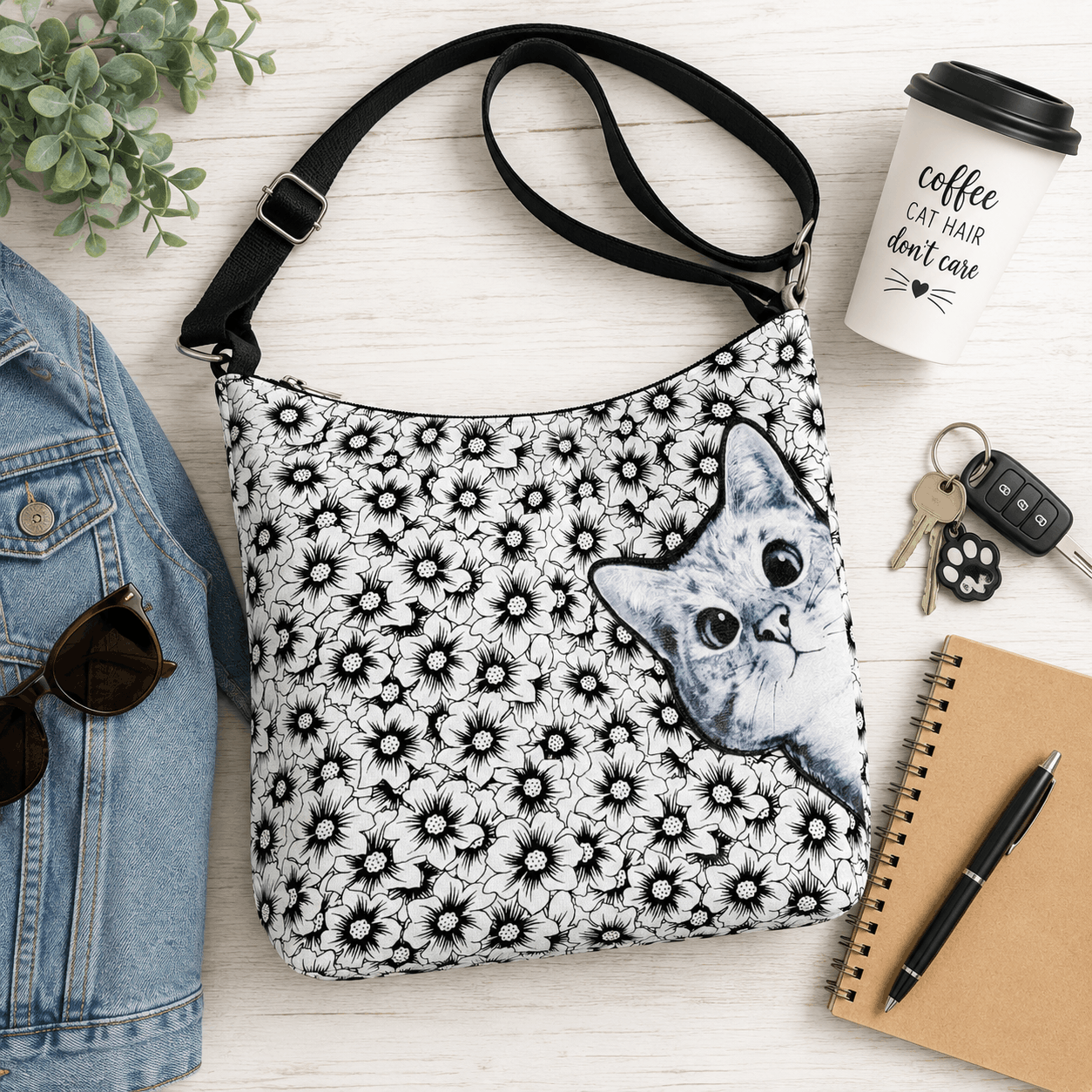 Peekaboo cat floral canvas shoulder bag styled with everyday essentials in a flat lay