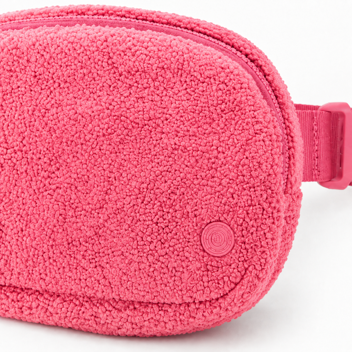 Close-up of the pink fleece texture, zipper, stitching, and tonal emblem