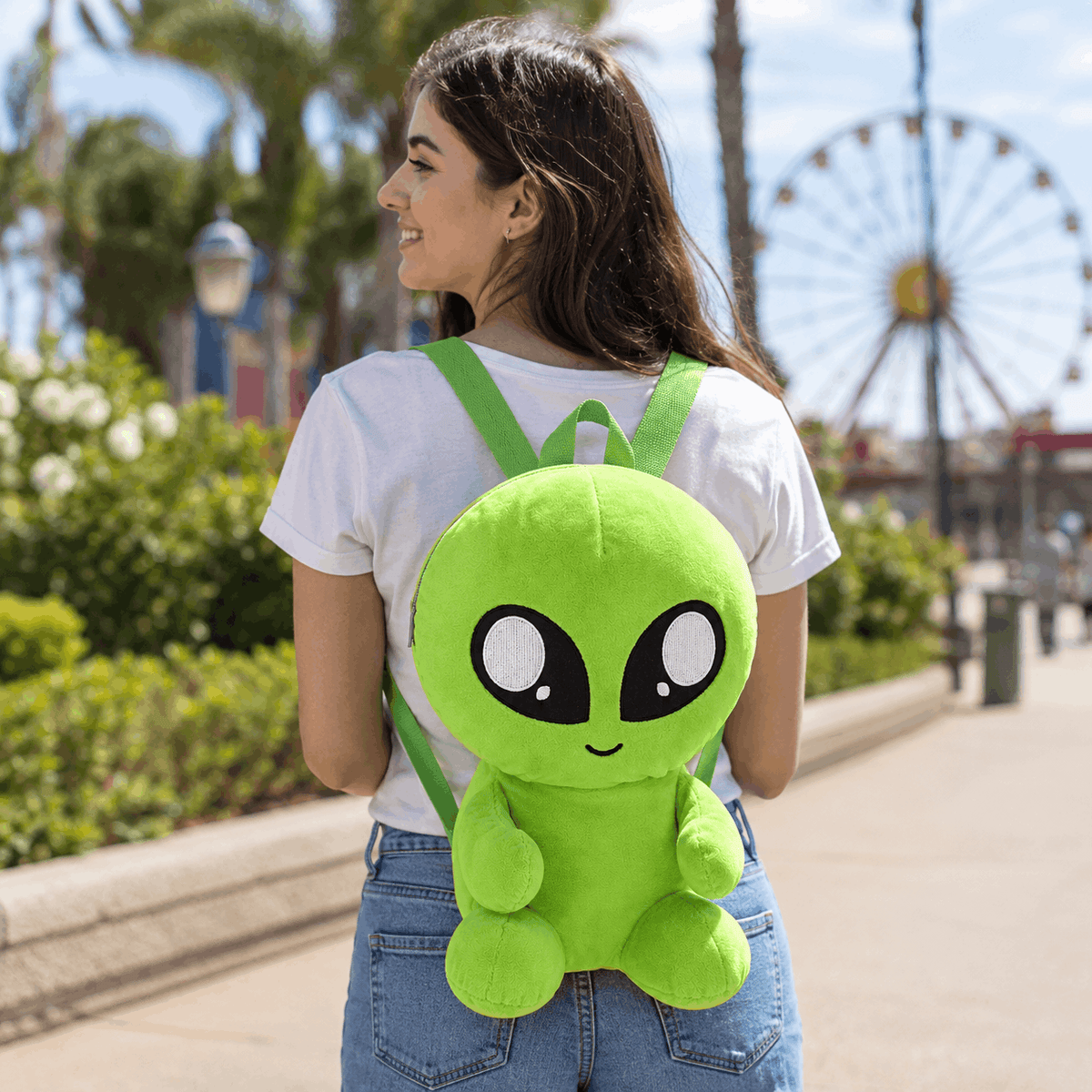 Person wearing the Plush Baby Alien Mini Backpack outdoors, showing its fun novelty design and everyday size.