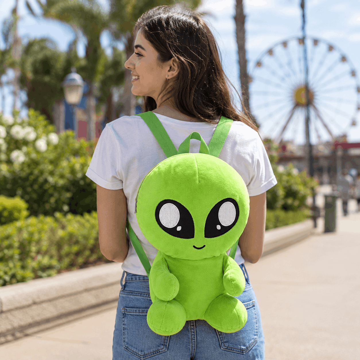 Person wearing the Plush Baby Alien Mini Backpack outdoors, showing its fun novelty design and everyday size.