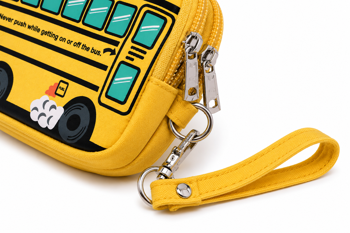 Close-up of the School Bus Mini Wristlet zipper hardware and detachable wrist strap.