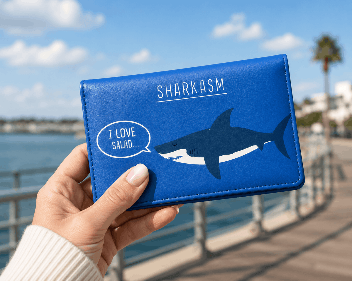Person holding Sharkasm bifold wallet showing its size and playful shark design