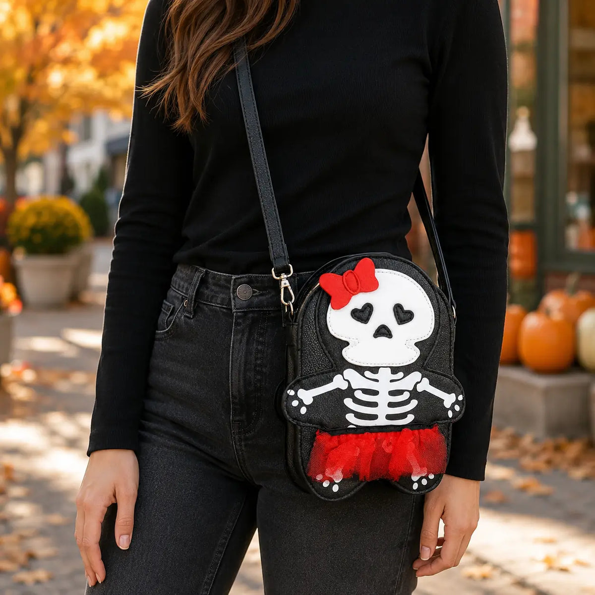 Skeleton girl crossbody bag worn with a black outfit in an autumn setting