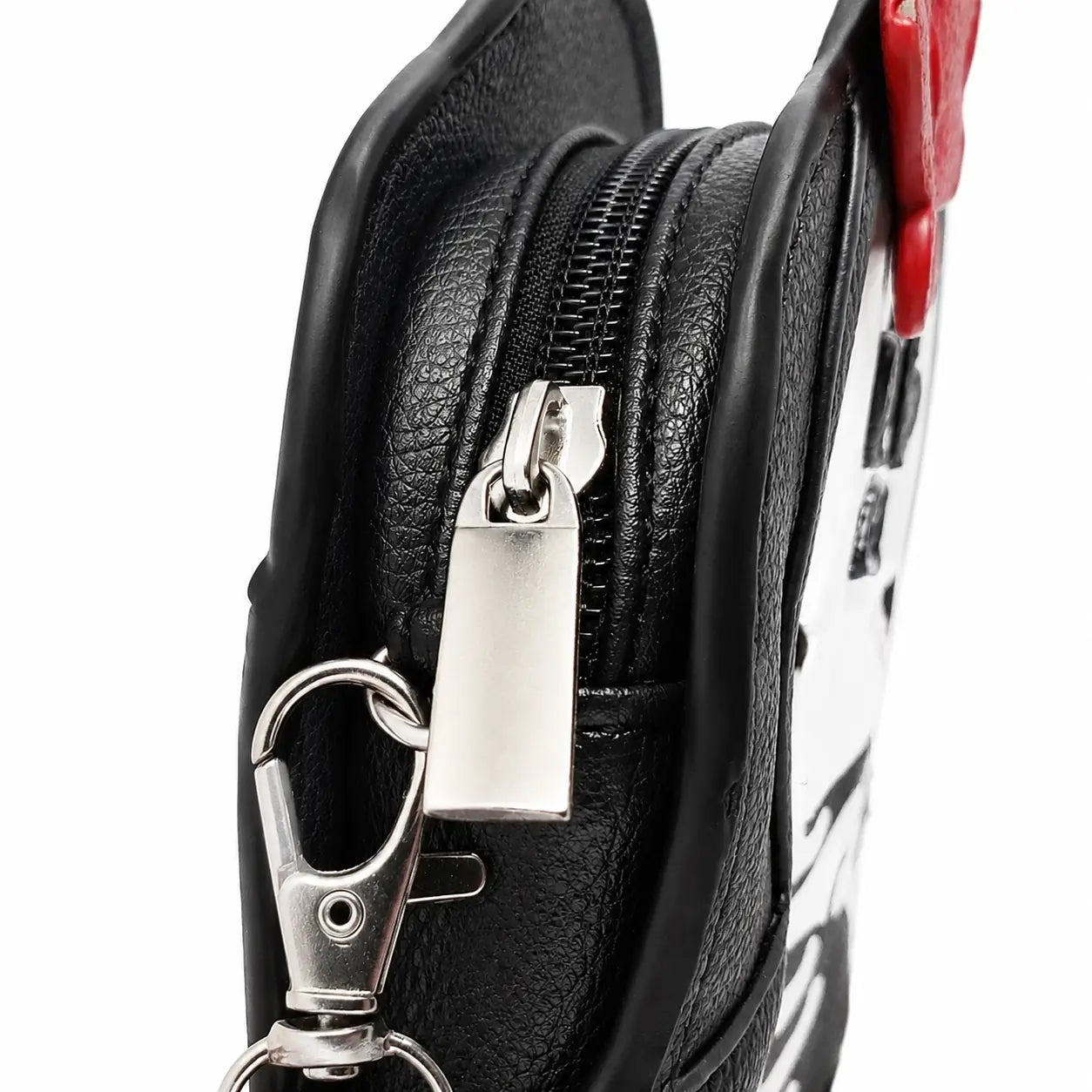 Close-up of zipper, silver hardware, and strap clip on skeleton crossbody bag