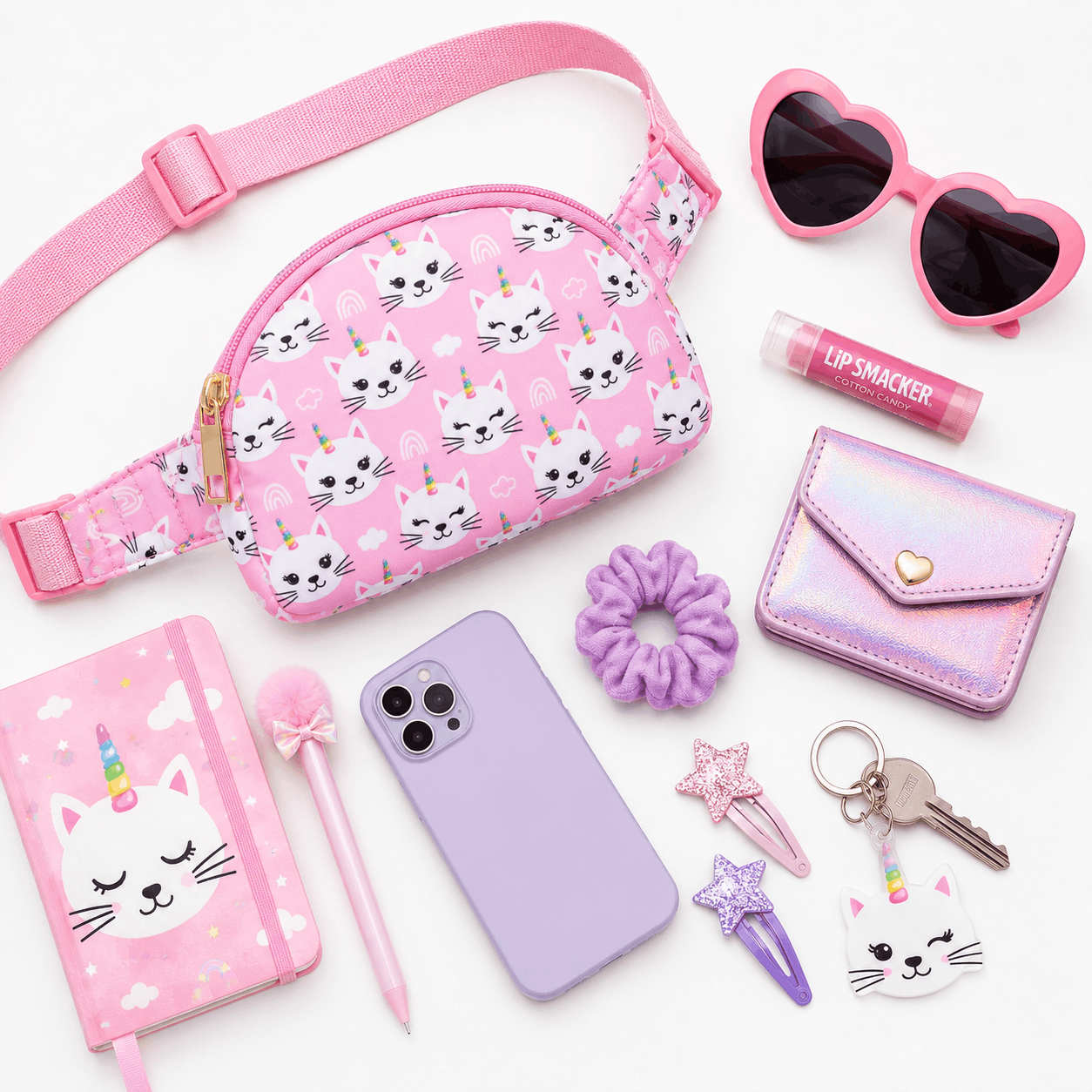 Unicorn Kitties belt bag displayed with everyday essentials including sunglasses, phone, wallet, notebook, keys, and accessories.